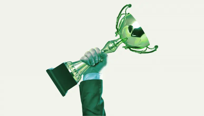 Winner hand holding a golden cup